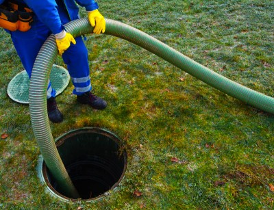 Envirodrain operative feeding a suction hose into a septic tank