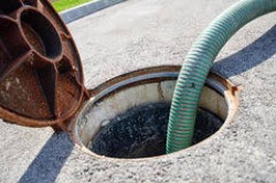 Open manhole with suction hose during de-sludging