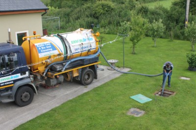 Envirodrain tanker de-sludging a septic tank in a garden